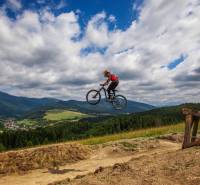 A cyclist is jumping on a mountain bike over the landscape in the recreational grounds near Mýto pod Ďumbierom.