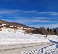 A snowy landscape with wooden cottages on recreational grounds near Fongrub Street in Mýto pod Ďumbierom.