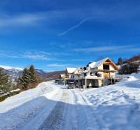 A snowy landscape and houses under construction on plots in Mýto pod Ďumbierom.