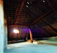 Attic in a family house with wooden beams and a window.