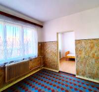 Interior of a family house with tiles, a radiator, and a window with a curtain.