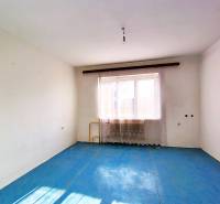 An empty room with white walls and a blue floor in a family house.