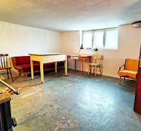 Basement in a family house with furniture and a window, concrete floor.