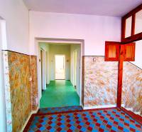 A hallway in a family house with colorful tiles and wooden wall paneling.