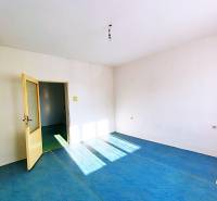 A room in a family house with a blue floor and open doors.