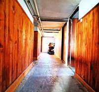 A hallway with wooden paneling and a motorcycle in a family house.