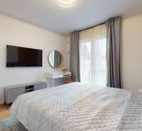 Bedroom in a 2-room apartment with a TV and a wooden decor floor.