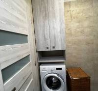 Washing machine with storage space in the bathroom of a 2-room apartment.