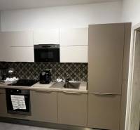 A kitchen in a 2-room apartment with modern appliances and patterned tiles.