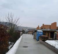 Construction of a family house on a snowy street in Višňové in the state of rough construction.