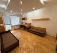 Living room in a three-room apartment with a wooden decor floor and a work desk.