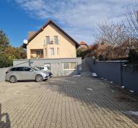 A parking lot with two cars in front of a family house on Jelenecká Street in Nitra.