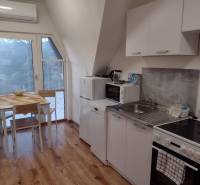 A kitchen in a family house with a wooden decor floor and a dining table.