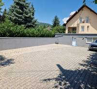 A family house on Jelenecká Street in Nitra with a landscaped yard and a car.