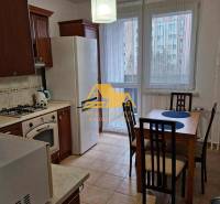 Kitchen in a 3-room apartment with a dining table and appliances, floor with wood decor.