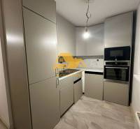 A kitchen in a 2-room apartment with modern cabinets and appliances.