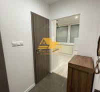 Interior of a 1-room apartment with tiles and flooring with a wood decor.