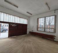 Interior of a garage with a wooden decor floor and a metal gate.