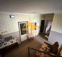 Interior of a family house with patterned wallpaper, furniture, and floral decoration.