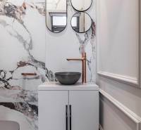 Marble sink with round mirrors and a copper faucet in a 2-room apartment.