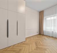 Interior of a 2-room apartment with a wooden decor floor and a large wardrobe.