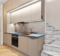 A kitchen in a 2-room apartment with a marble staircase and a wooden decor floor.