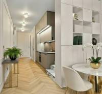 Interior of a 2-room apartment with a kitchen, dining table, and floor with wooden decor.