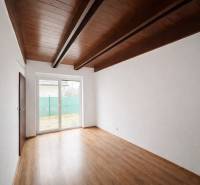 A room in a family house with a wooden decor floor and a large window.