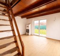 Interior of a family house with a staircase, fireplace, and wooden decor flooring.