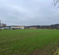 Lands - commercial in Pruské with a view of buildings in the distance and a field.