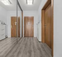A hallway in a 2-room apartment with a wooden decor floor and a built-in wardrobe.