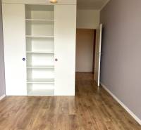 A room with a white shelf and a wooden decor floor in a 3-room apartment.