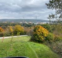 Autumn landscape in Bratislava - Dúbravka on Nejedlého, with colorful trees and a sky full of clouds.