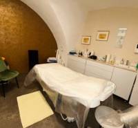 Massage table in commercial premises with vaulted ceiling, including accessories.