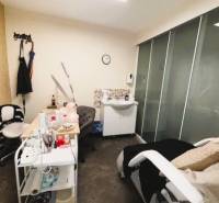 Beauty salon with a chair, table, and sink in commercial premises.