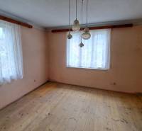 A room in a family house with two windows and a floor with a wooden decor.