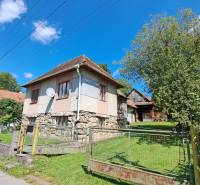 A family house on Kalameny Street in Ružomberok surrounded by greenery and blue skies.
