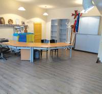 Offices with wood-decor flooring, tables and chairs, decorated with flags and items.