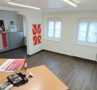 Offices with wood-decor flooring and flags on the wall.