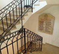 Interior of offices with a spiral staircase and a board on the wall, floor with wood decor.