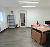 Offices with wood-patterned flooring, a desk, and an empty shelf.