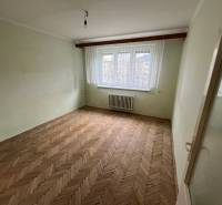 A room in a 3-room apartment with a wooden decor floor and a large window.