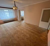 A spacious room in a 3-room apartment with a wood-decorated floor and a large window.