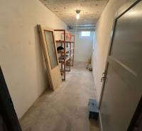 Storage space with shelves and a window in a 3-room apartment, without flooring.