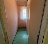 A narrow room with a built-in wardrobe and a curtain in a 3-room apartment.