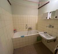 Bathroom in a 3-room apartment with a bathtub, sink, and tiled walls.
