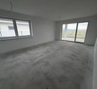 Empty room with a concrete floor and a large window in a family house.