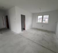 Interior of a family house with white walls and concrete floor, large window.