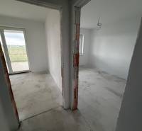 Two rooms in the interior of a family house with white walls and a concrete floor.