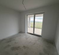 A room in a family house with a gray floor and large windows facing the yard.